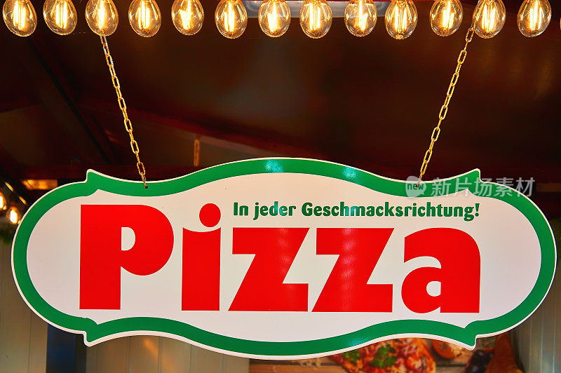 发光的披萨店标志。用In jder Geschmacksrichtung写的信意思是每一种味道。